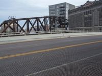 a bridge with a bicycle that is attached to it and buildings and street lights on top of it