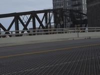 a bridge with a bicycle that is attached to it and buildings and street lights on top of it