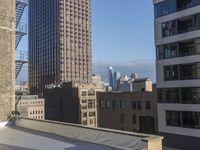 two men that are standing on the roof of a building under a clear blue sky