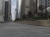 people on a bicycle are crossing an empty road near tall buildings in a city neighborhood