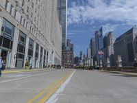 several people are walking through a deserted city street with tall buildings on either side of it