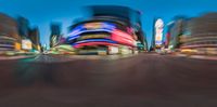 some blurry image of an area with lots of buildings in it at night with street lights