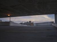 a view of a city from inside a car park in the evening, with buildings on the other side