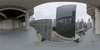 a city seen from a fish - eye lens on a bridge and in a city