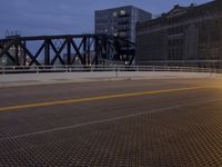 a night shot of a bridge across the water from buildings at twilight with no people