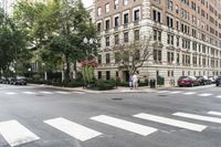 a busy intersection with some cars and people crossing the street in the city for cars