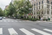 a busy intersection with some cars and people crossing the street in the city for cars