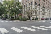a busy intersection with some cars and people crossing the street in the city for cars