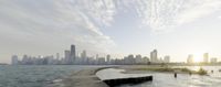 a city skyline with a large body of water in the foreground and sky line