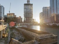 this photo shows the river and buildings in a city skylined by a construction crane