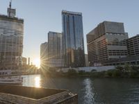 this photo shows the river and buildings in a city skylined by a construction crane