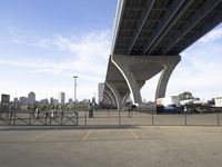 an empty parking lot with a bridge in the background and buildings on either side of it