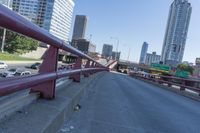 cars and trucks are driving along the freeway in front of a large city skyline while it stretches across a street