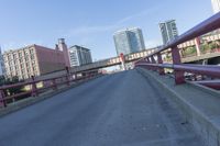 cars and trucks are driving along the freeway in front of a large city skyline while it stretches across a street