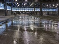 an empty airport parking garage with water on the floor and lights on above it,