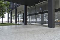 a parking lot with glass windows is lined up by trees in the area of the building