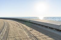 the bike is parked on the edge of a cement wall overlooking the ocean and coastline