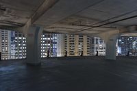 large, empty parking garage with many windows open to let in some light from the city skyline