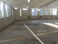 an empty parking garage with no windows with no doors to access and the floor is gray