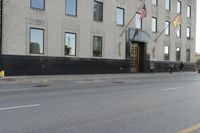 people walking in front of a large office building on the street in front of a building