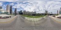 this photo is showing cars and buildings in a city on the road, taken through a fisheye lens