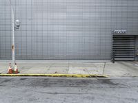 a parking meter sits at the corner of a street in front of a garage door