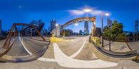 there is an 360 - view image of a bridge on a street at night time