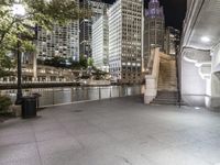 a city street filled with tall buildings and buildings next to a river and a walkway