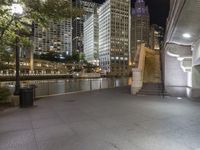 a city street filled with tall buildings and buildings next to a river and a walkway