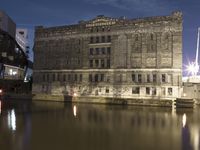 an image of a castle on the riverbank at night time in europe, europe