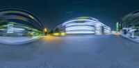 blurred night scene of a road that has curves and curves with buildings in the background