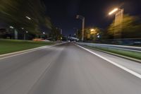 an empty street at night with blurred lights in the background and a car driving down the road