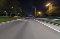 an empty street at night with blurred lights in the background and a car driving down the road