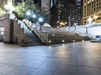 a man riding his skateboard across a walkway next to a building at night on a sidewalk