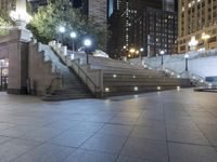 a man riding his skateboard across a walkway next to a building at night on a sidewalk