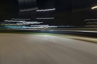 motion blur from cars traveling down an empty street at night time, with lights of cars passing by