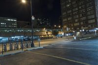 a parking lot with some bike racks in it near a gate and light poles at night