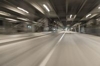 a blurry image of a tunnel, looking toward the camera from inside of it