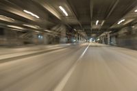 a blurry image of a tunnel, looking toward the camera from inside of it