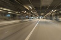 a blurry image of a tunnel, looking toward the camera from inside of it