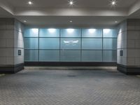 a lobby in a building with lights on and brick floors below a wall and floor tileed area