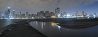 a photo of a city skyline by water in the night time and the water at the edge has no light