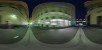 a blurry image of buildings in the night, with an upside down lens at their feet