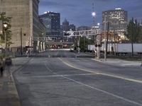 an empty city street with pedestrians walking on it at night to stop for cars to turn