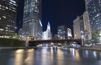 a river is seen between two buildings in a downtown area at night, with city lights on