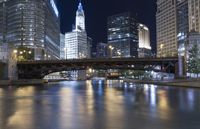 a river is seen between two buildings in a downtown area at night, with city lights on