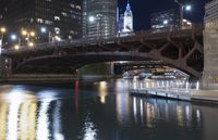 a river is seen between two buildings in a downtown area at night, with city lights on