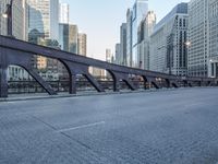 a city street with lots of traffic going over the bridge and in the middle of buildings