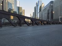 a city street with lots of traffic going over the bridge and in the middle of buildings