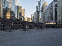 a city street with lots of traffic going over the bridge and in the middle of buildings